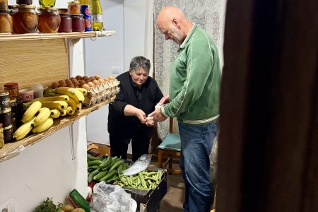 Pat koopt bananen bij de buurvrouw in het kasteel van Berat