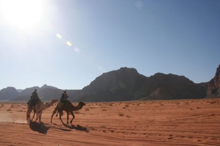 Een toerist met gids hobbelt door de woestijn