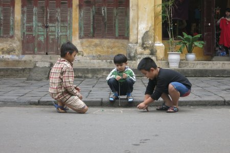 Kinderen knikkeren in de straatjes van Hoi An