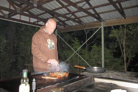 Pat bakt vlees op de BBQ van de camping