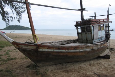 Een oud vissersbootje op het strand van